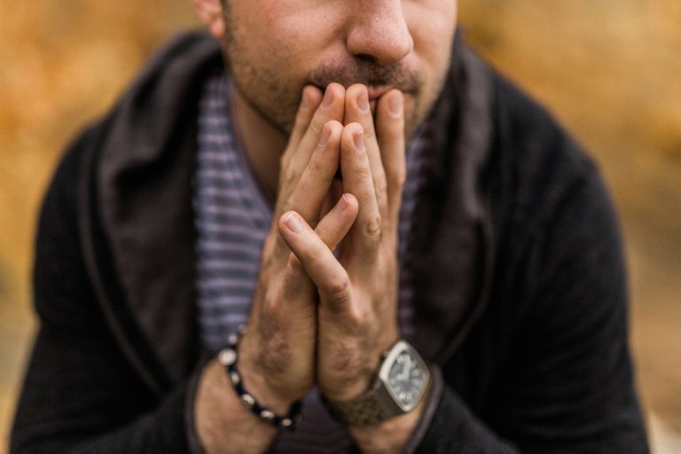 Person with their hands together and to their lips representing worry, anxiety and concern for blog about OCD, PTSD and cognitive behavioural therapy
